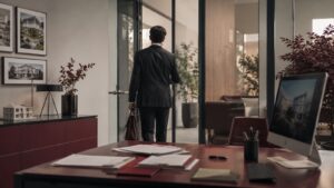 Agente inmobiliario saliendo de una oficina, símbolo de la rotación de talento en las agencias