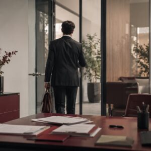 Agente inmobiliario saliendo de una oficina, símbolo de la rotación de talento en las agencias